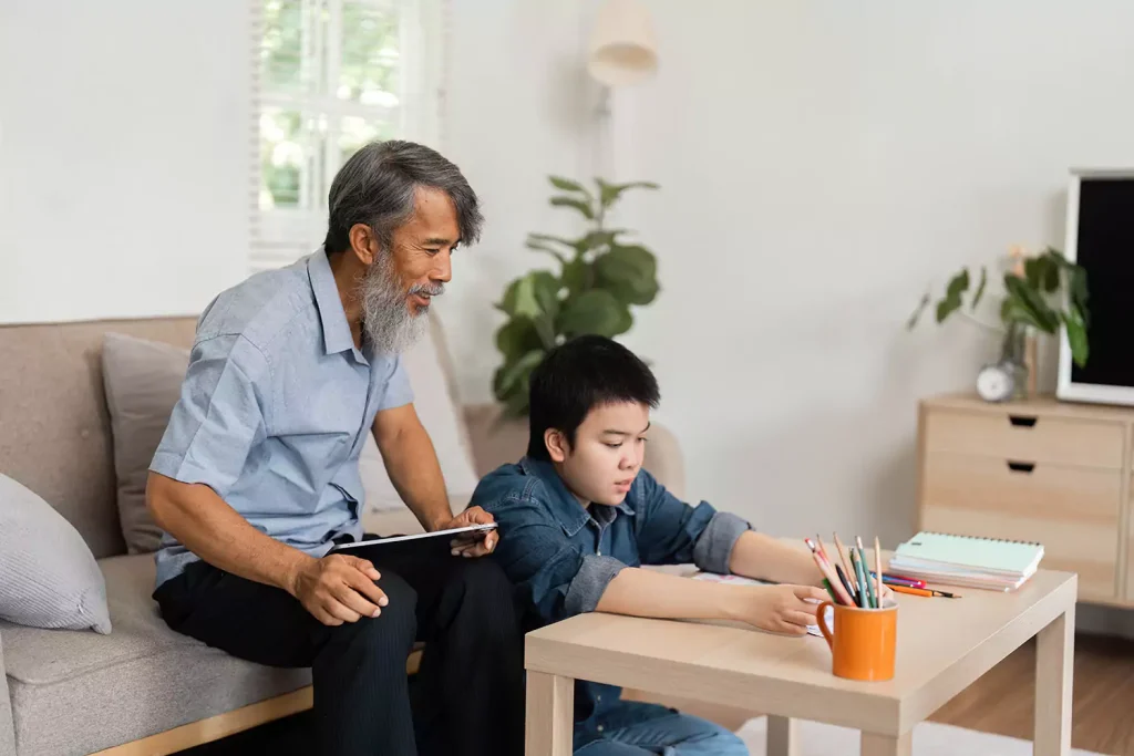 A young disabled girl is enjoying some creative time, drawing with her care provider